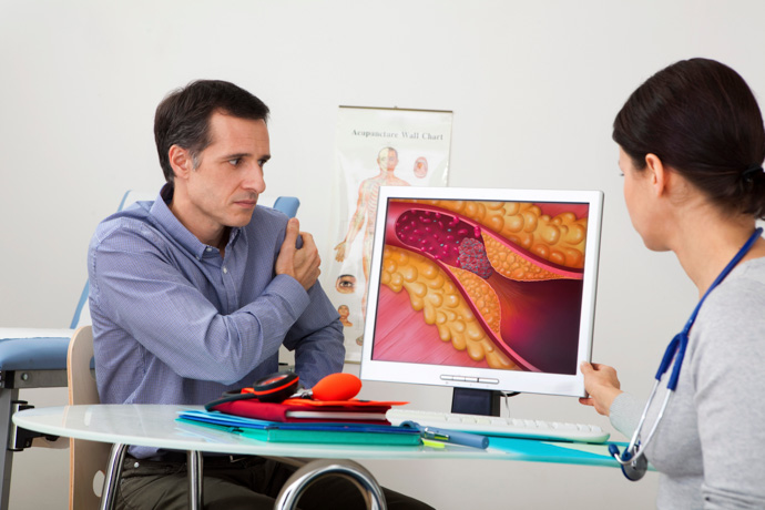 Doctora enseñando al paciente cómo bajar el colesterol de forma natural.