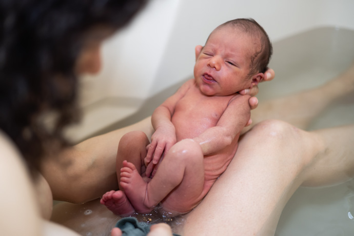 Madre bañando a su bebé recién nacido en una bañera.