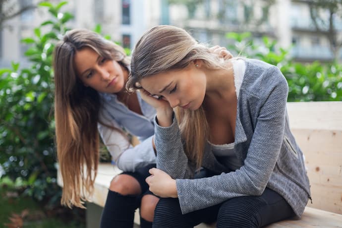 mujer animando a una persona triste