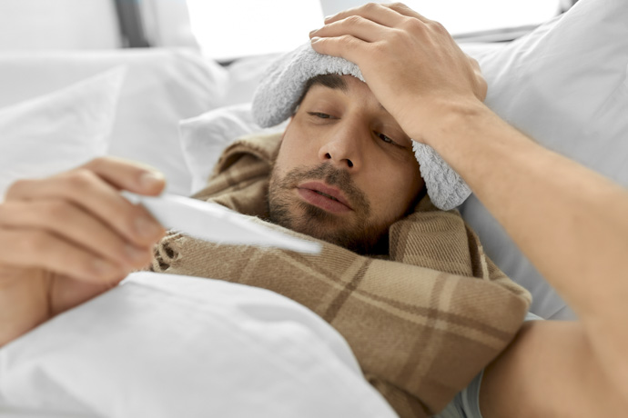 Hombre con fiebre y resfriado común