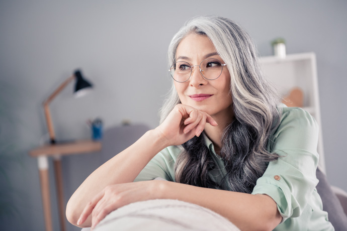 Mujer pensando en por qué le salen canas.