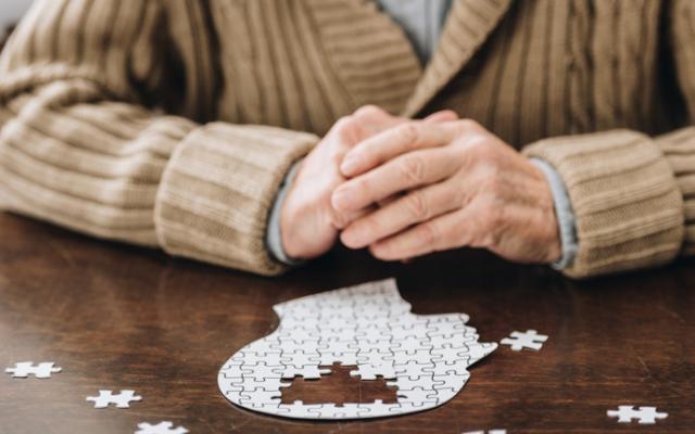 Hombre con deterioro cognitivo leve realizando un puzle. 