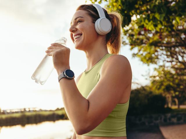 Mujer tomando agua ddurante una caminata 