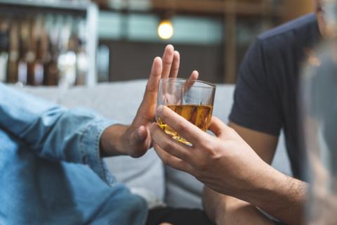 Hombre que sabe cuánto tarda el cuerpo en eliminar el alcohol rechazando una copa.