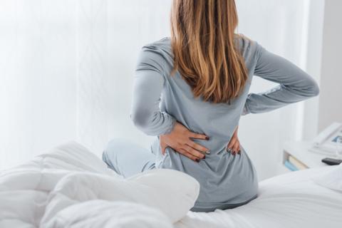 Mujer con dolores de espalda y cáncer.