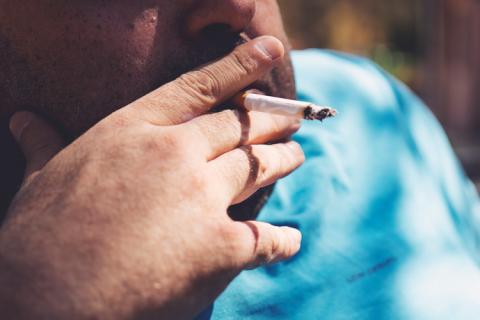 hombre con sobrepeso fumando