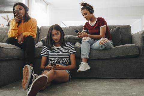 Grupo de adolescentes usando teléfono para ver memes